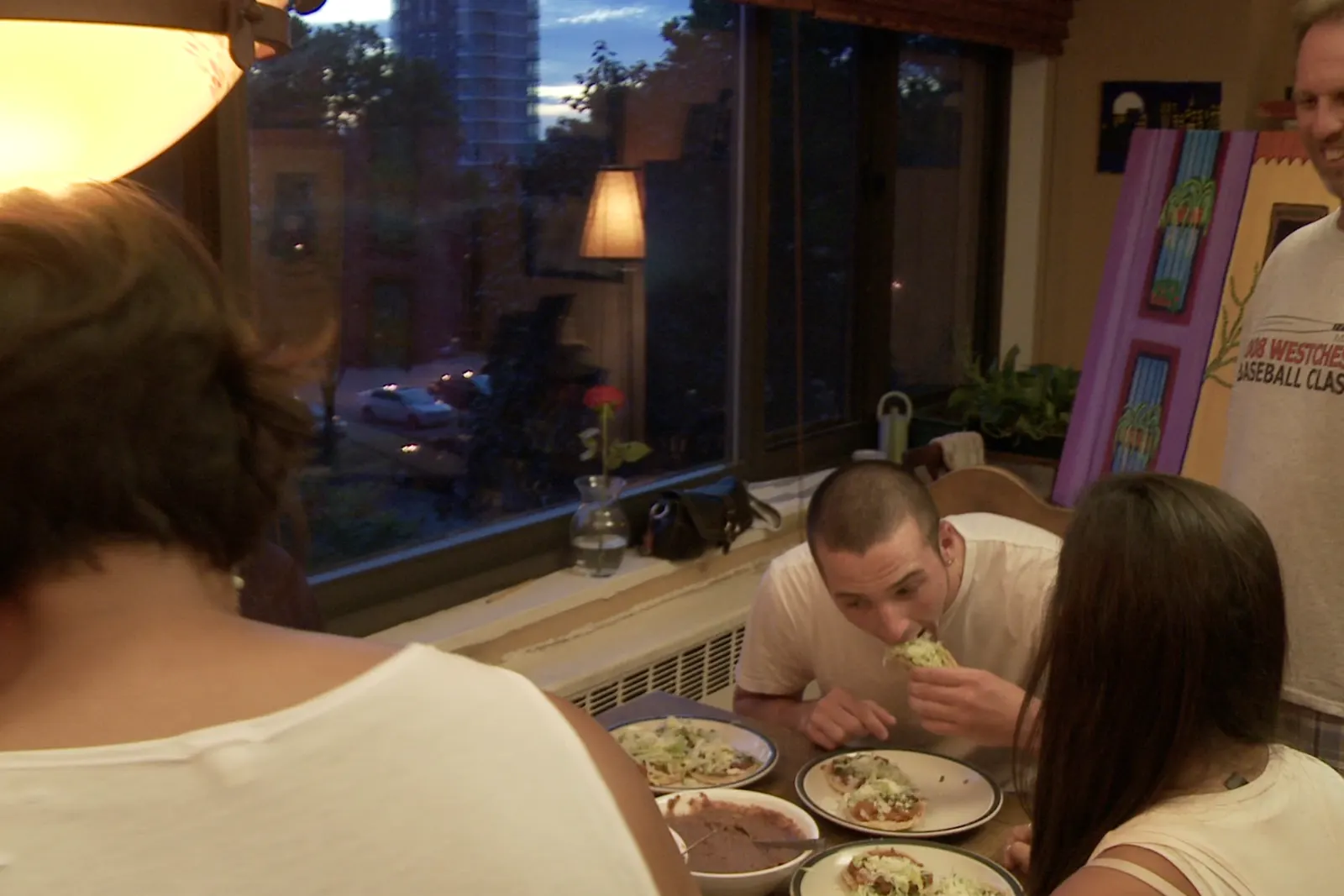 The family at the table as the window darkens