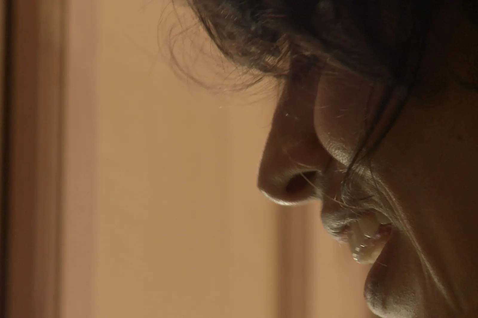 Carmen in profile, lit low and thinking