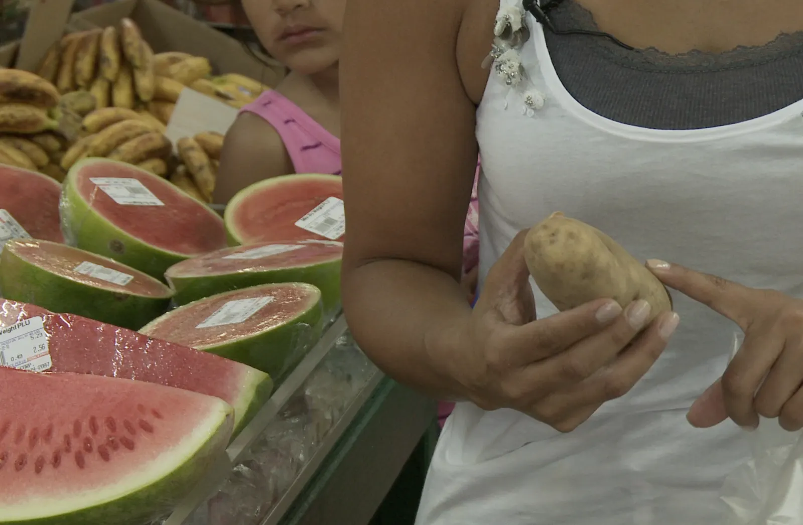 Choosing produce beside cut watermelon